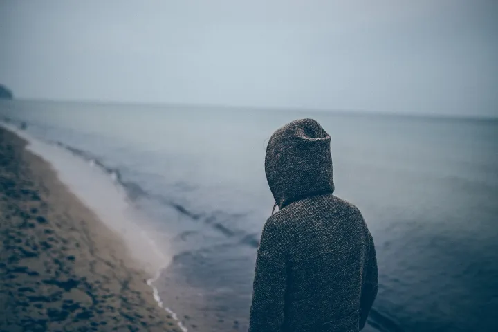 A person walking alone on a beach (public domain)